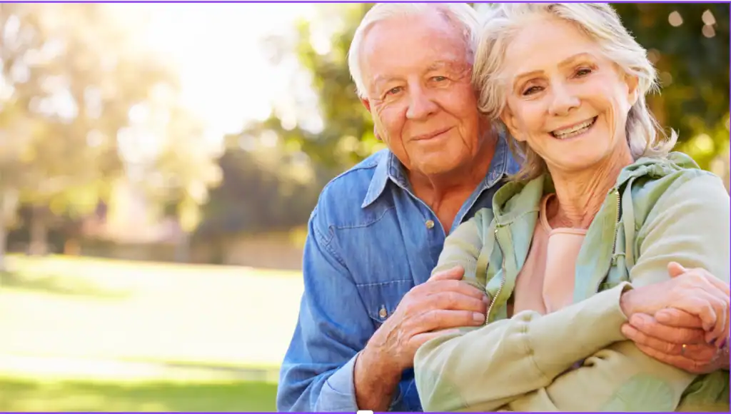 Smiling senior couple outdoors reviewing Medicare Initial Enrollment Period options